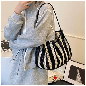 Detail of striped mesh shoulder bag featuring breathable fabric and minimalist design