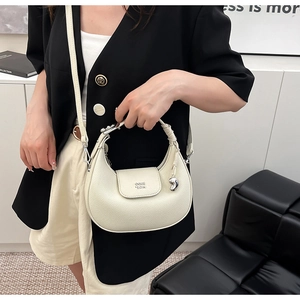 Dettaglio della borsa a mezzaluna beige con trama litchi e tracolla arricciata elegante
