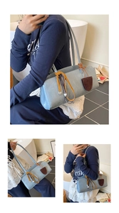 Détail du sac bowling bleu avec cordon jaune et pendentif en forme de cœur argenté
