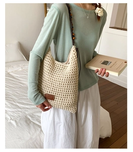 Detail of hollow woven tote bag featuring beaded shoulder straps and leather logo tag