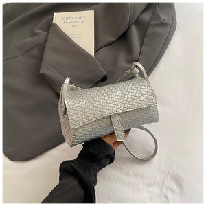 Detailed view of silver woven crossbody bag with metallic finish and flap closure