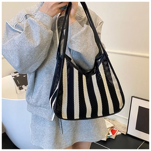 Detail of black and white striped mesh tote bag with durable leather trim and straps