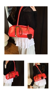 Détail du sac polochon rouge vintage avec breloque cœur et cordes tissées colorées