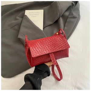 Close-up of red woven texture and flap design on a chic minimalist shoulder bag