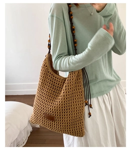 Detail of hand-woven hobo bag with beaded shoulder strap and leather patch detail