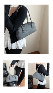 Detail of grey denim Boston bag showing dual zippers and long shoulder straps