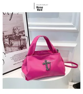 Dettaglio della borsa a tracolla in ecopelle rosso rosa con croce d'argento e catena