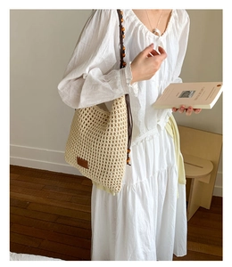 Detailed view of woven tote with handmade crochet texture and wooden bead shoulder strap