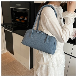 Blue denim shoulder bag shown on model in a stylish kitchen setting, minimalist retro style