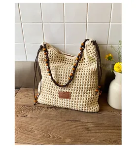 Detailed close-up of woven hollow-out pattern and leather brand label on the tote bag