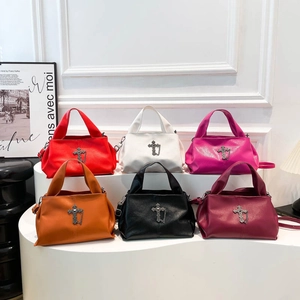 Cross pendant tote bags in six colors including red, black, and white on a display stand