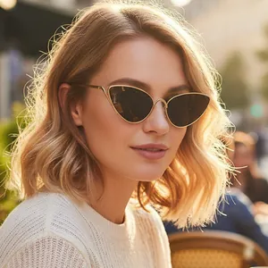Vintage retro cat eye sunglasses with gold metal frame and dark lenses on fashion model