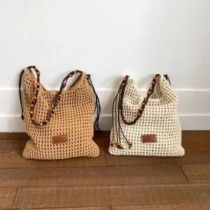 Handwoven hollow tote bag in khaki and beige with wooden bead straps and leather patch