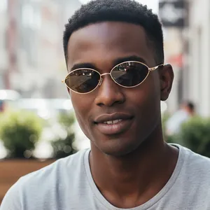 Retro oval metal sunglasses with gold frames and dark lenses in an outdoor setting