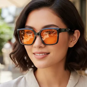Quadratische Y2K-Sonnenbrille mit schwarzem Rahmen und orangefarbenen Gläsern am Modell