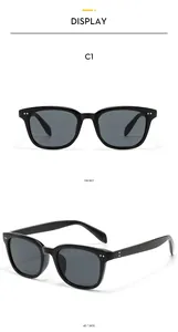 Vue détaillée de lunettes de soleil carrées noires avec rivets argentés et verres UV foncés
