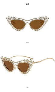 Detail view of gold metal cat-eye sunglasses with luxury rhinestones and floral accents