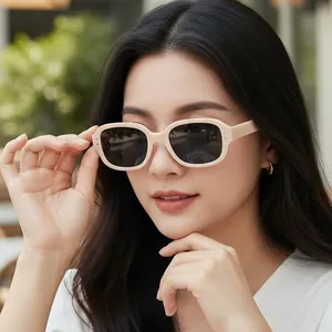 Retro-Sonnenbrille in Beige mit rechteckigem Rahmen und dunklen Gläsern am Modell