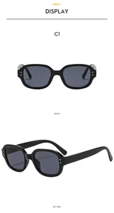 Details einer schwarzen rechteckigen Sonnenbrille mit silbernen Nieten und Gläsern