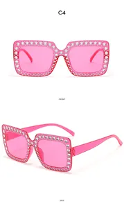 Gros plan sur les lunettes de soleil carrées rose vif ornées de strass argentés sur la monture
