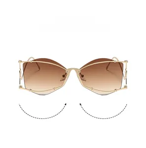 Détail de lunettes de soleil dorées tendance avec verres dégradés bruns et logo EYESHINE