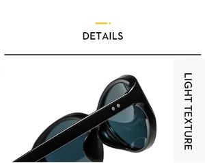 Close-up of sleek black oval sunglasses hinge with silver studs and deep blue lenses
