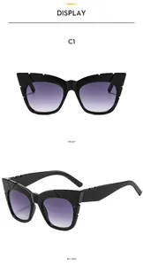 Detail view of black cat-eye sunglasses with purple gradient lenses and geometric frame
