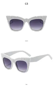 Detail view of white cat-eye sunglasses with geometric texture and purple gradient lenses