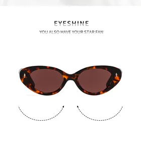 Detail of tortoiseshell cat-eye sunglasses with gold arrow metal trim and dark brown lens