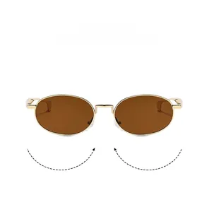Close-up of luxury oval sunglasses featuring gold metal frames and amber tinted lenses