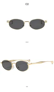 Macro view of gold metal oval sunglasses with dark gray lenses and refined side temples