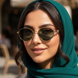 Retro oval metal sunglasses with gold frame and green lenses worn by a model in soft light
