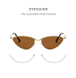 Détail de lunettes de soleil œil-de-chat ovales avec monture dorée et verres marron