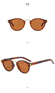 Detail view of tortoiseshell cat-eye sunglasses with gold metal bridge and brown lenses