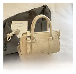 Close-up of off-white lychee grain leather handbag with silver hardware and shoulder strap