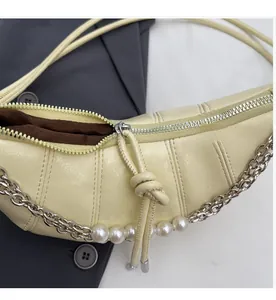 Detail of cream croissant bag featuring smooth metal zipper and quilted faux leather texture