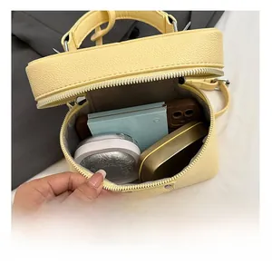 Interior view of small yellow crossbody bag showing capacity for phone and cosmetics