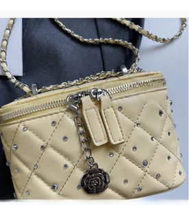 Close-up of quilted chain bag featuring crystal rhinestones and camellia charm detail