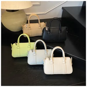 Litchi pattern leather handbags in five colors with silver zippers on a black tiered stand