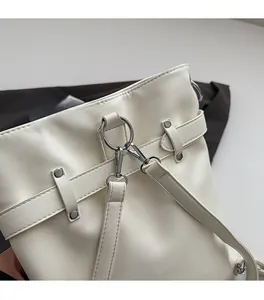 Close-up of premium silver hardware and white leather buckles on a stylish backpack