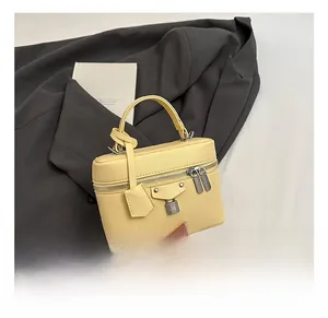 Detail of light yellow lychee pattern handbag with silver lock and double zipper design