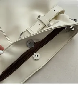 Detail of minimalist cream drawstring backpack with magnetic buckle and adjustable strap