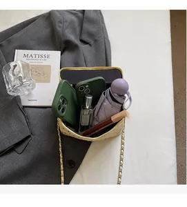 Internal storage detail of quilted chain bag showing phone, perfume and umbrella