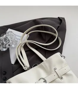 Close-up of white pleated backpack with silver buckle and comfortable dual shoulder straps