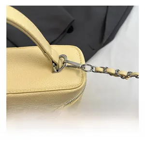 Detail showing the litchi texture leather and premium silver metal hooks of the handbag