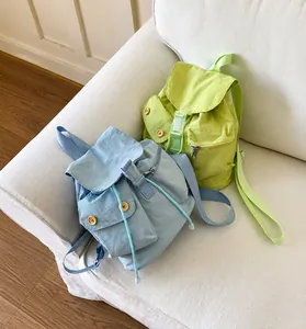 Detail of light blue and lime green canvas backpacks with flap and button closure