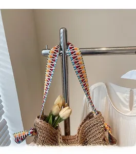 Dettaglio di borsa tote in paglia intrecciata con tracolla geometrica colorata