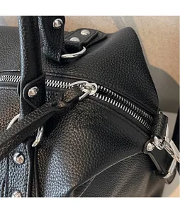 Dettaglio borsa tote nera in pelle martellata con borchie argentate e anelli a D