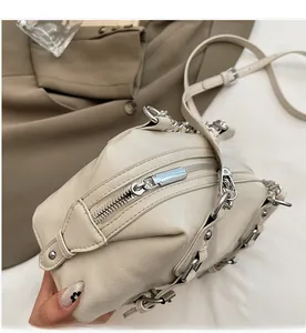 Close-up of smooth silver zipper and fine leather texture on a beige crossbody bag