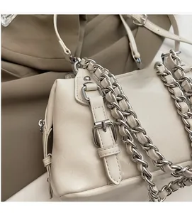Detailed macro view of beige lychee texture leather handbag with silver chunky chain strap